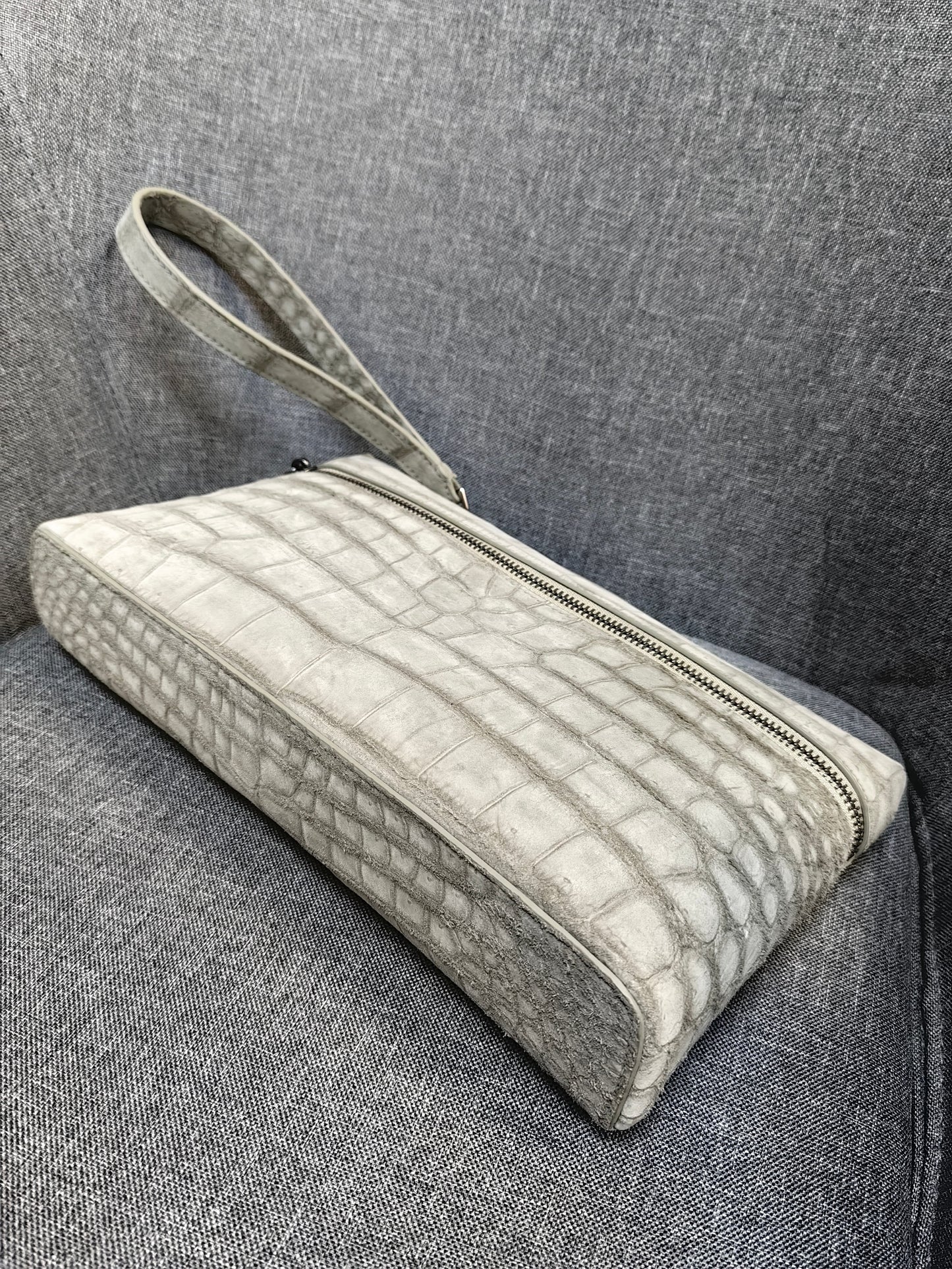 Unisex Rossie Viren crocodile skin leather clutch bag with zipper handle and nubuck finish.
