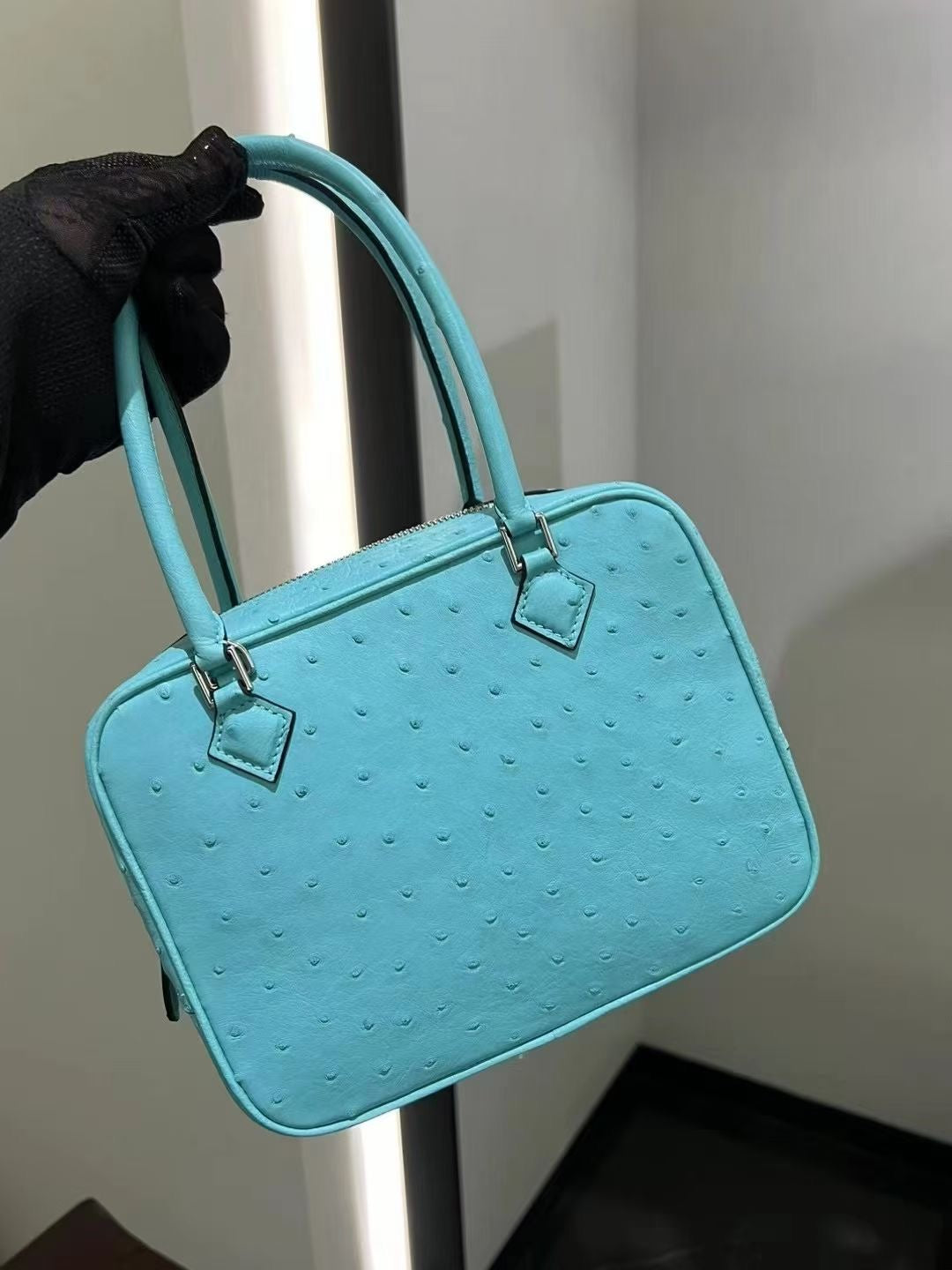 Women’s genuine ostrich skin leather handbag with a top handle, designed by Rossie Viren, showing its textured surface and elegant style.