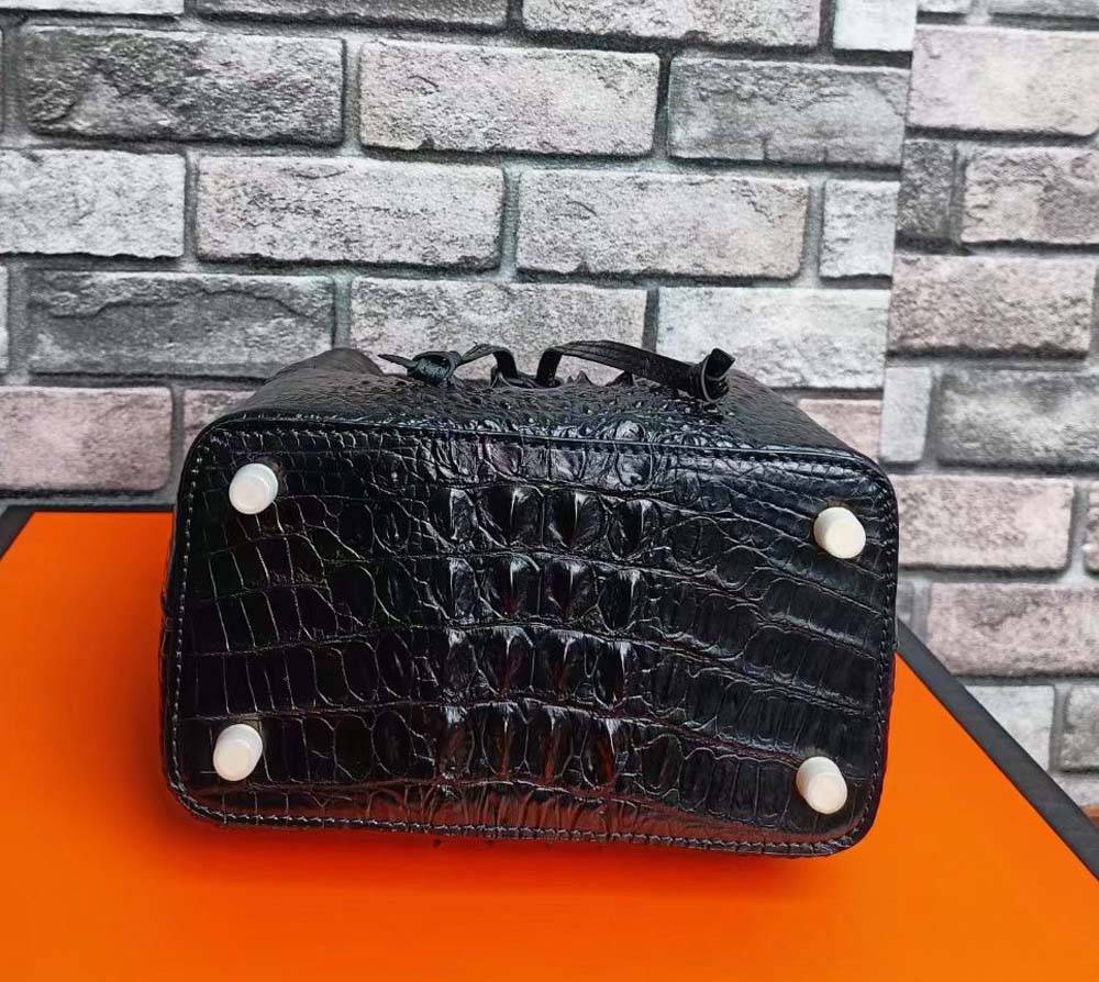 Rossie Viren crocodile leather bucket handbag with gold-tone hardware and adjustable strap, showcasing textured crocodile skin.