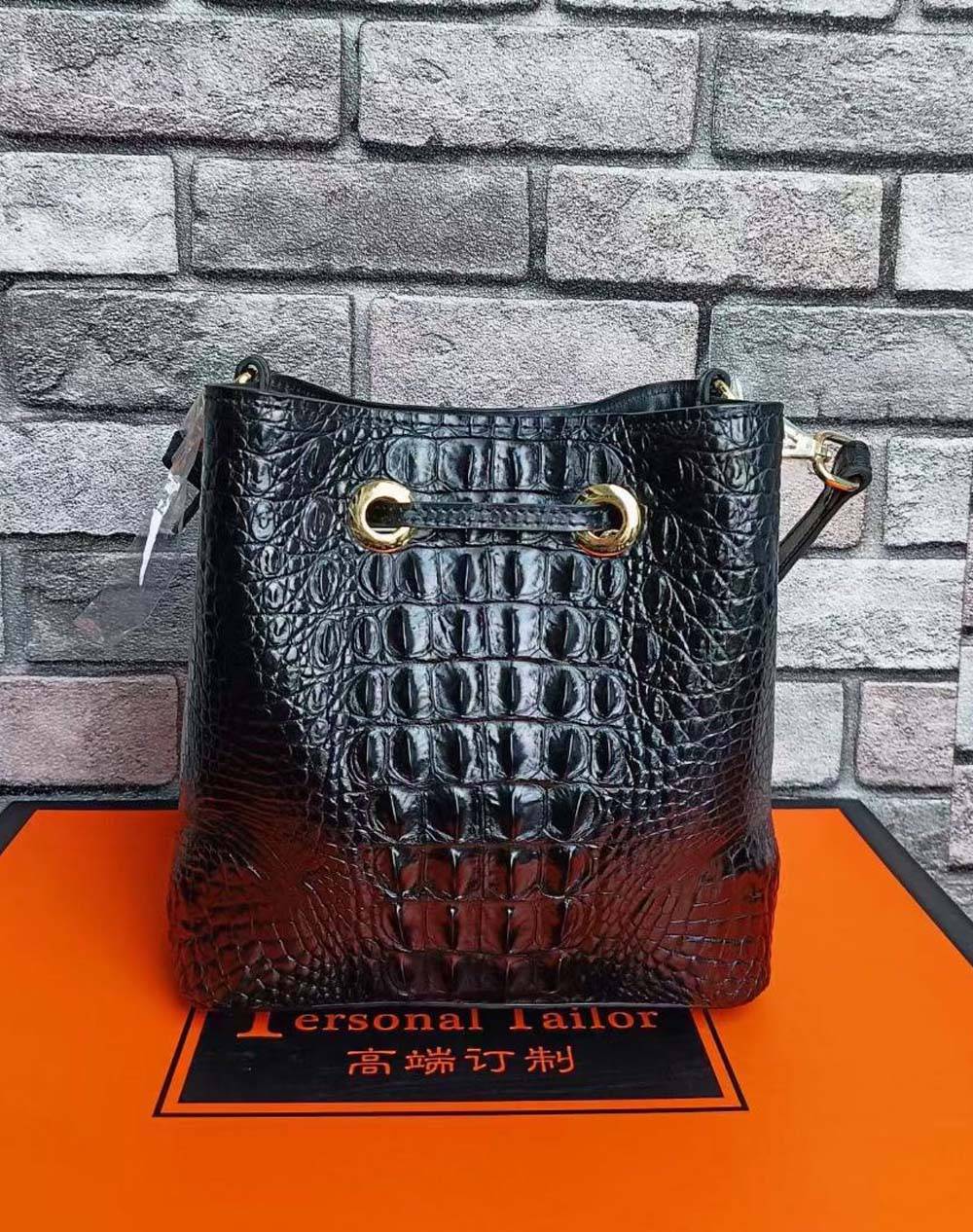 Rossie Viren crocodile leather bucket handbag with adjustable strap and gold-tone hardware, featuring a textured crocodile pattern.