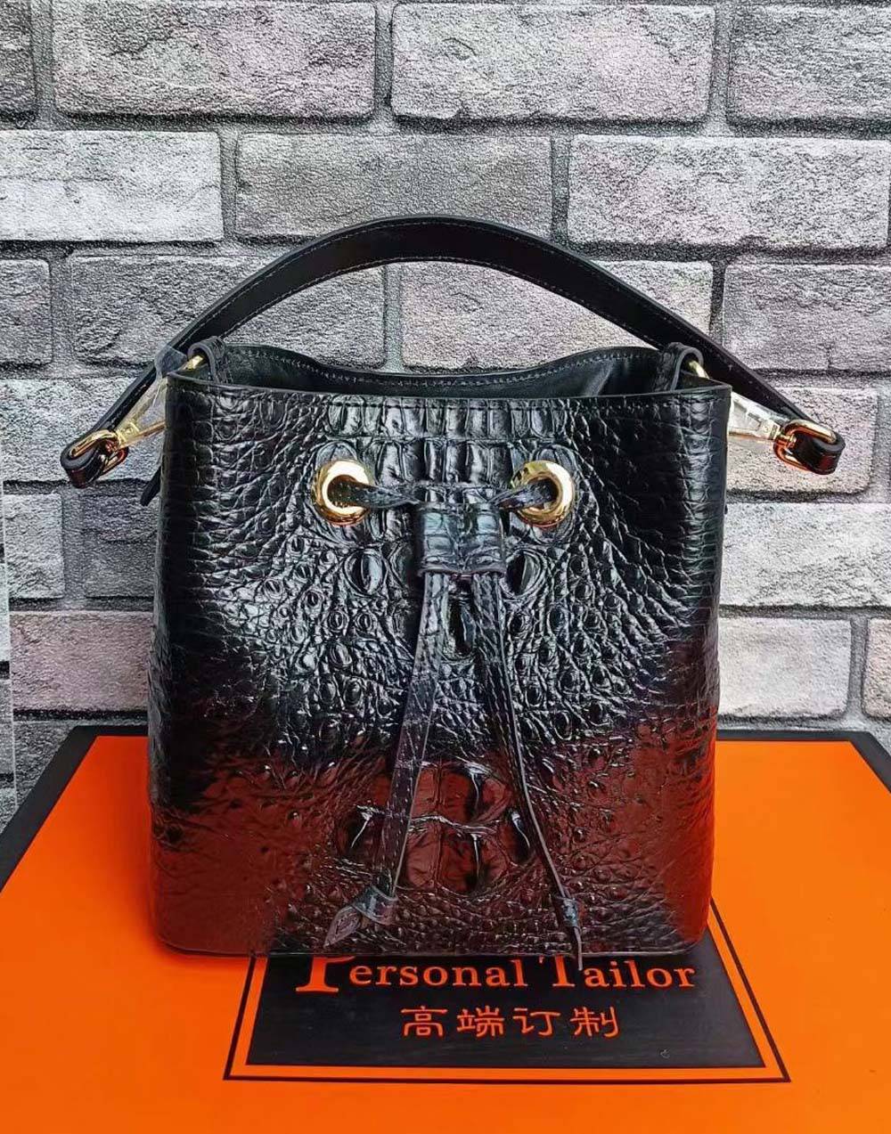 Crocodile leather bucket handbag by Rossie Viren with gold-tone hardware and adjustable strap, featuring a stylish, textured design.