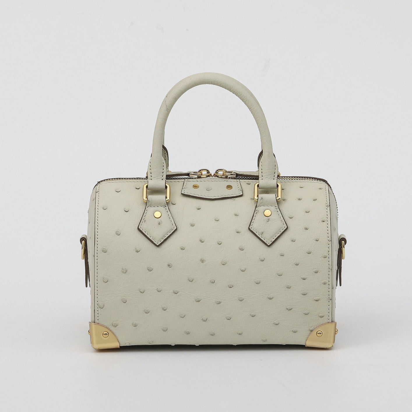 Women's genuine ostrich skin leather top handle pillow bag by Rossie Viren, showcasing its elegant design and textured surface.