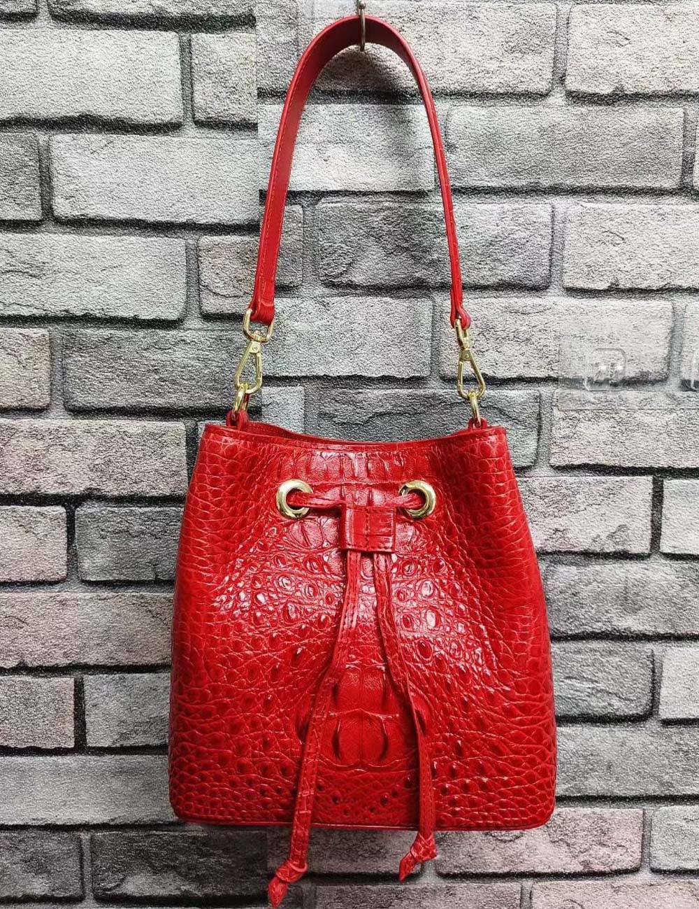 Rossie Viren crocodile leather bucket handbag with gold-tone hardware and adjustable strap, showcasing textured crocodile pattern.