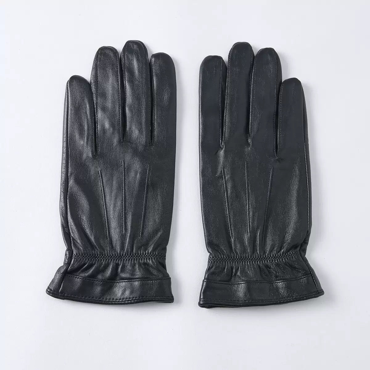 Black men's leather gloves by Rossie Viren, designed for stylish warmth, shown with a classic handbag in the image.