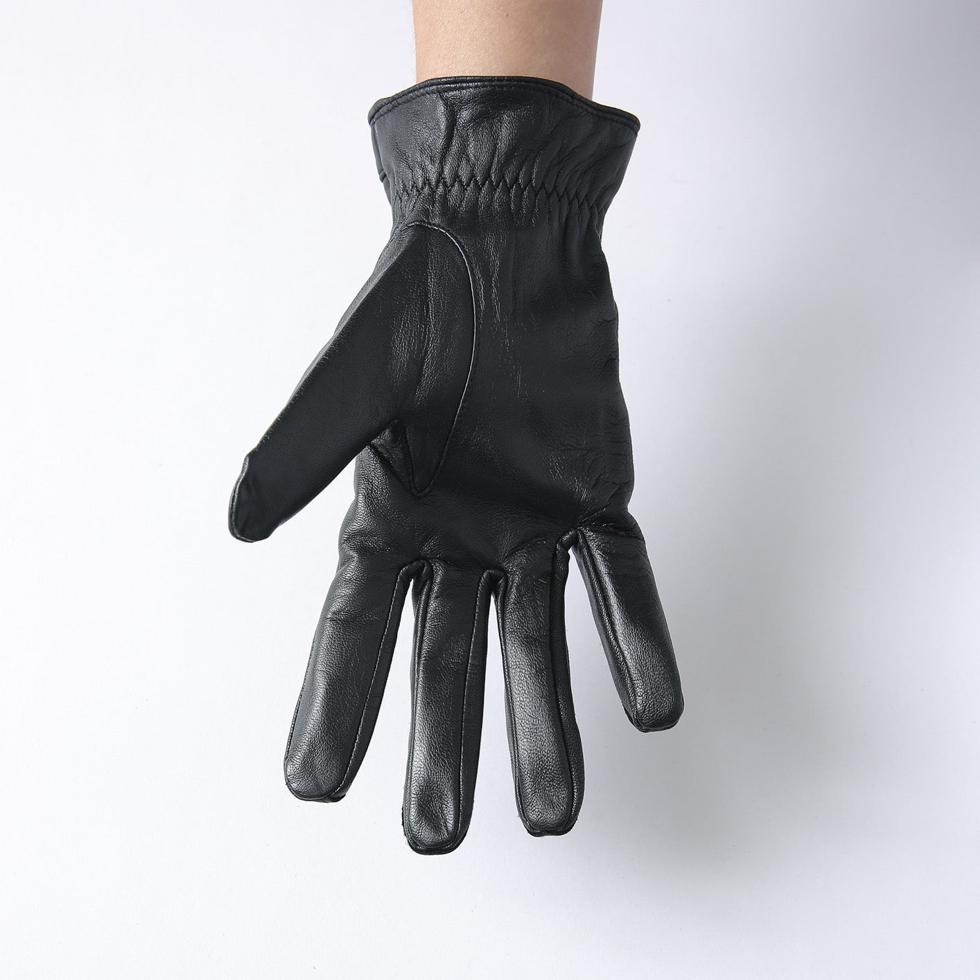 Black men's leather gloves by Rossie Viren, designed for style and warmth, displayed in a sleek handbag.