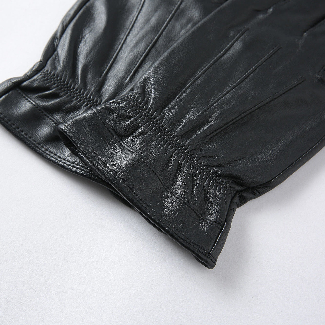 Black men's leather gloves from Rossie Viren, styled as a sleek handbag accessory in the image.