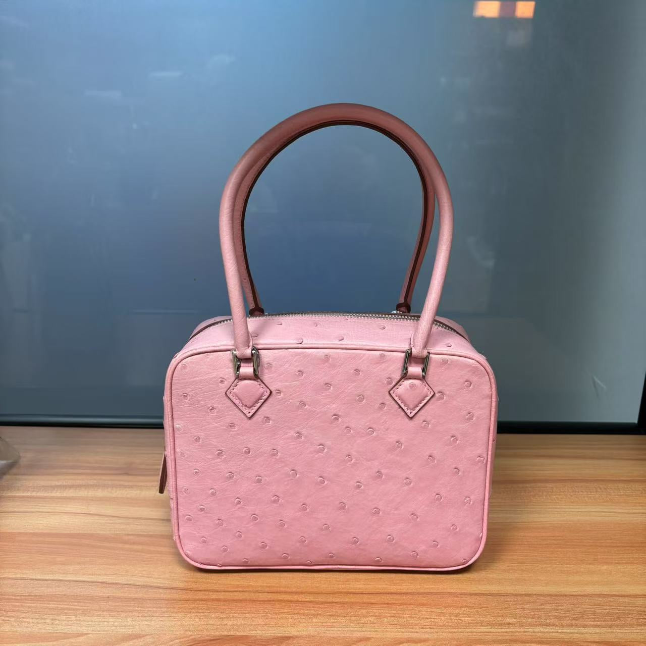 Women's genuine ostrich skin leather handbag with top handle by Rossie Viren, showcasing its textured leather and elegant design.