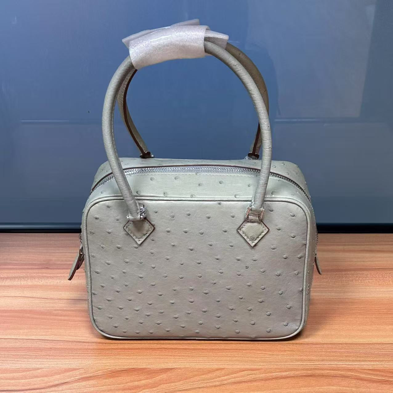 Women's genuine ostrich skin leather handbag with top handle by Rossie Viren, showcasing elegant texture and craftsmanship.