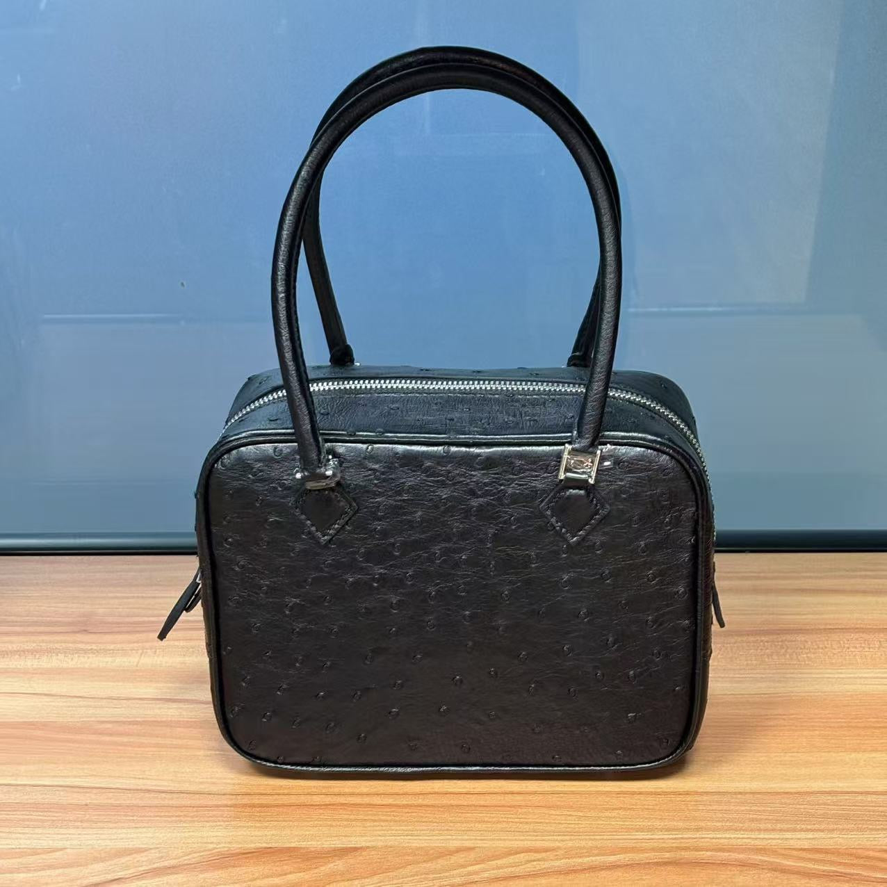 Women's genuine ostrich skin leather handbag with top handle from Rossie Viren, featuring a sleek, textured design.
