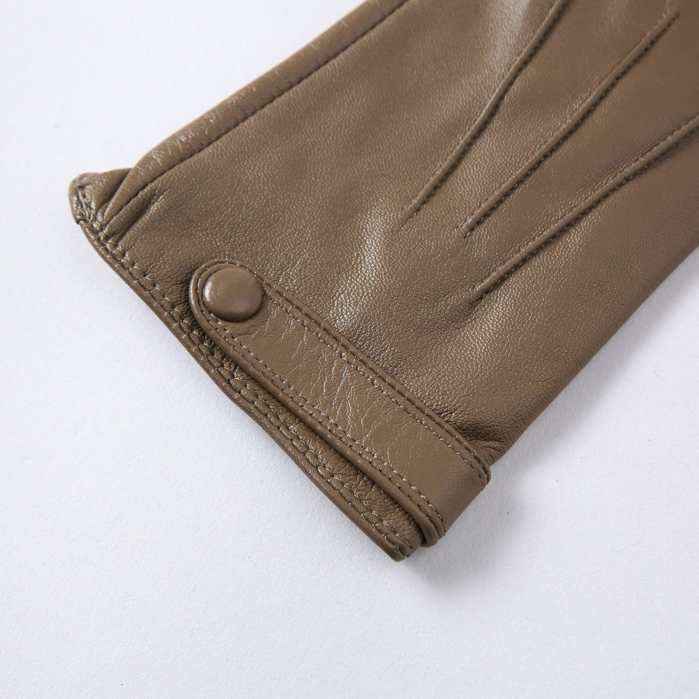 Close-up of Rossie Viren women's soft goatskin leather snap cuff gloves, showcasing their elegant design and smooth texture.