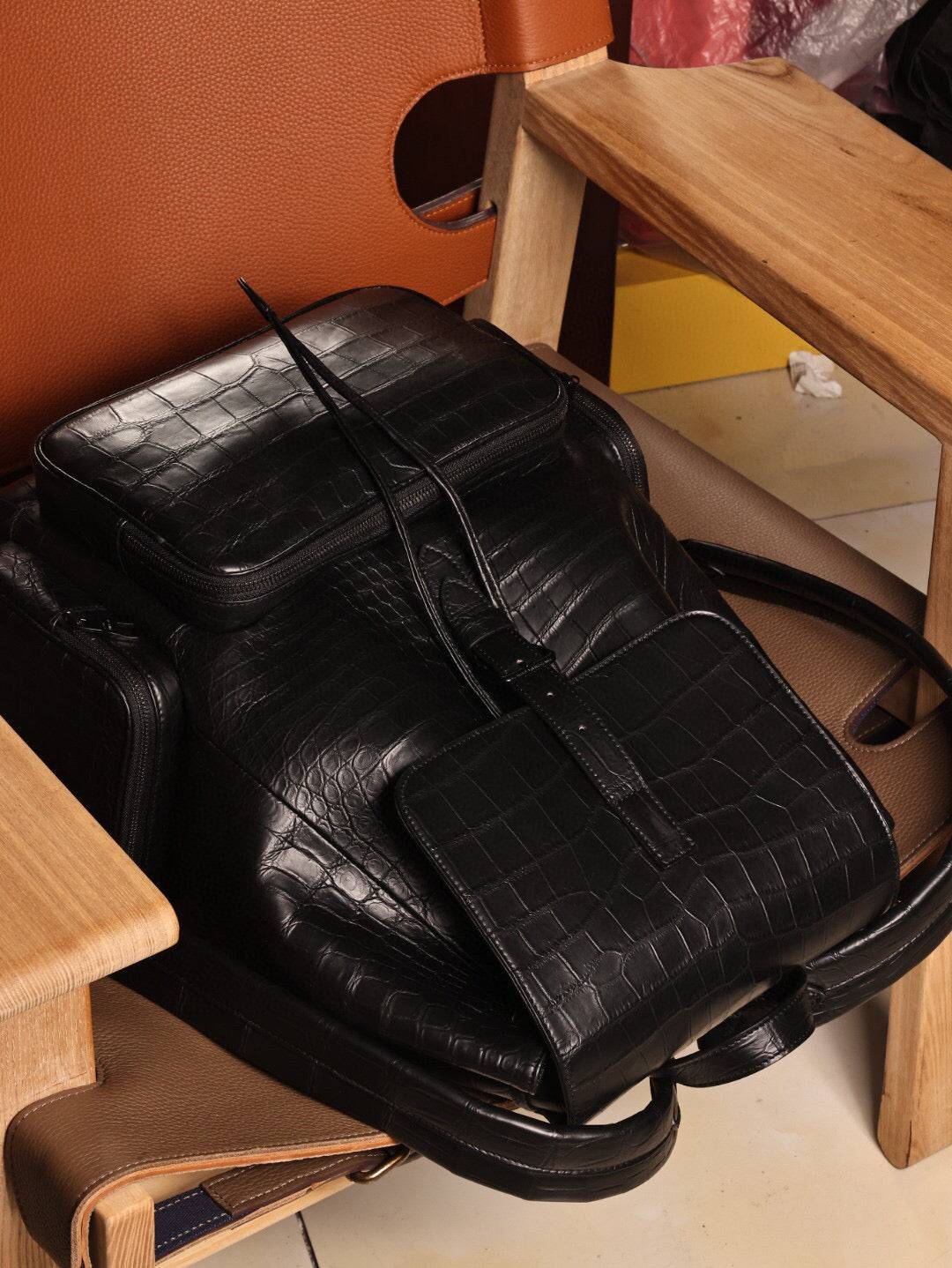 Unisex black crocodile leather backpack handbag with adjustable straps and silver hardware, designed by Rossie Viren.