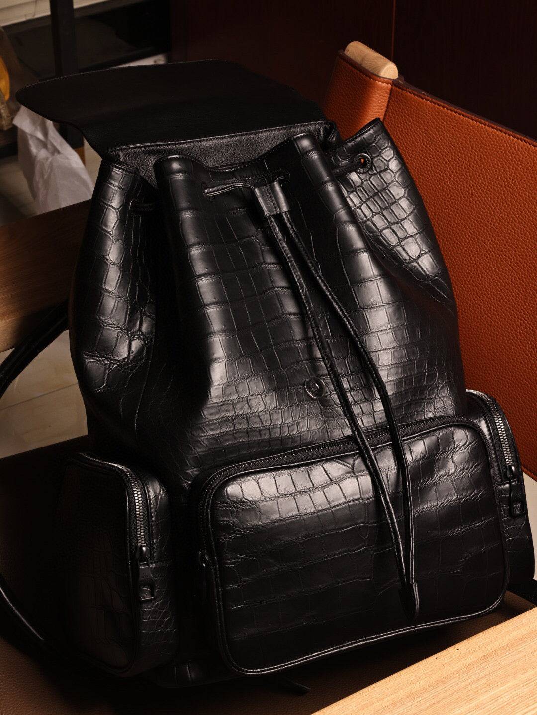 Unisex black crocodile leather backpack handbag with adjustable straps and gold-tone hardware, stylish and durable for everyday use.