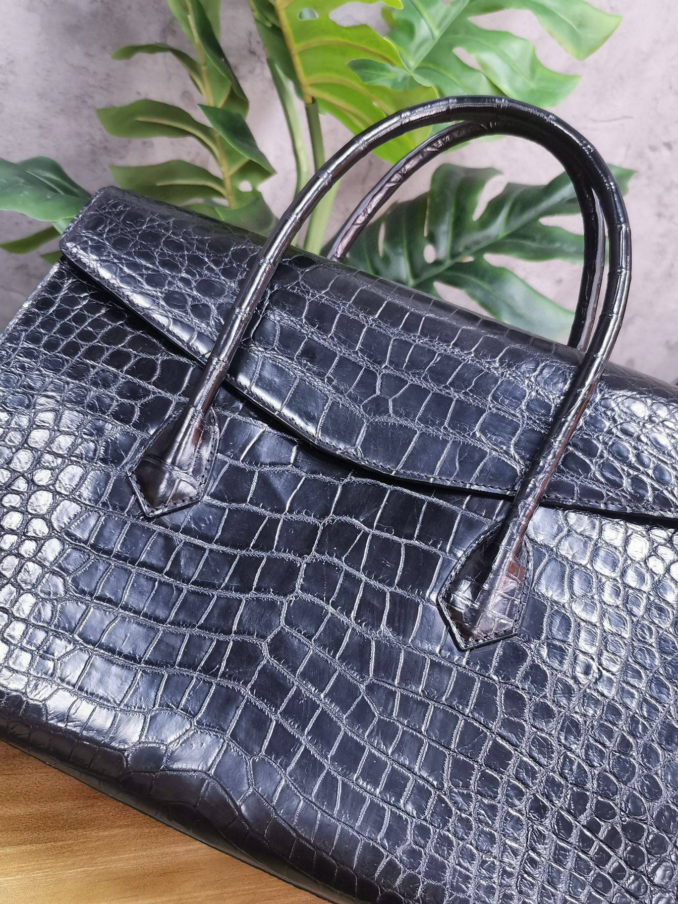 Rossie Viren crocodile leather briefcase with sturdy handle, featuring textured crocodile skin for business and laptop use.