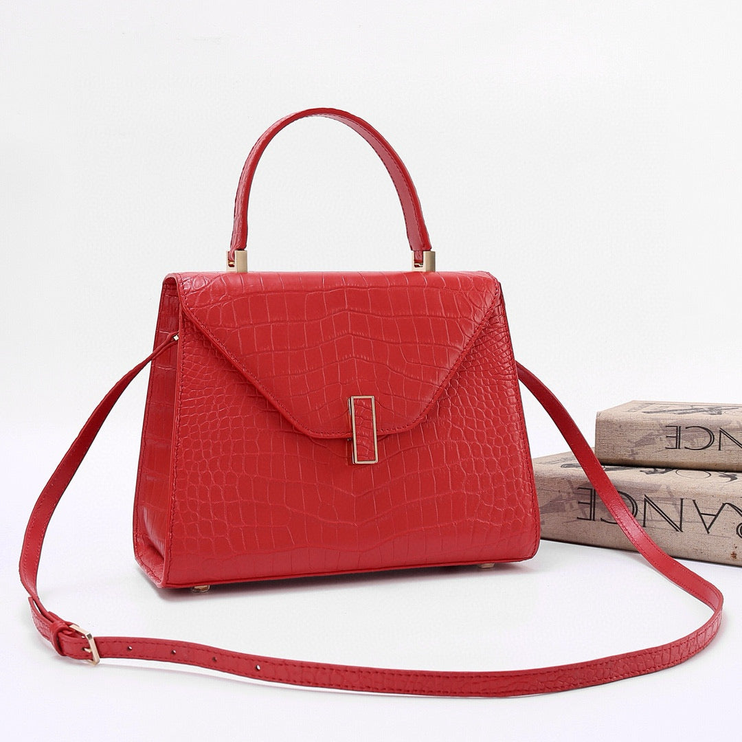 Red genuine crocodile skin leather top handle bag by Rossie Viren, featuring a sleek, structured design with a top handle and elegant finish.