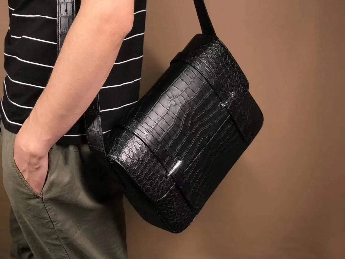 Matt washed genuine crocodile leather messenger bag by Rossie Viren, featuring a sleek shoulder strap and textured crocodile pattern.