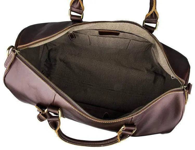 Vintage tan leather Rossie Viren carry-on luggage bag with sturdy handles and classic design, suitable for travel and storage.