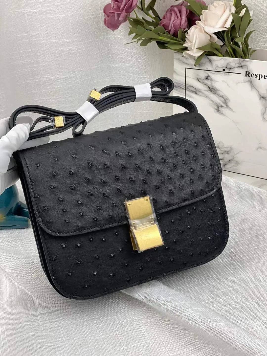 Women’s ostrich leather cross-body messenger bag by Rossie Viren with a sleek shoulder strap and textured finish.
