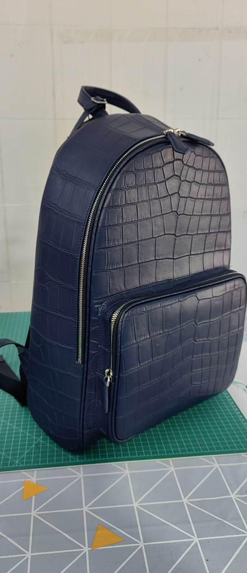 Large black crocodile leather backpack by Rossie Viren with sturdy straps and textured crocodile pattern.