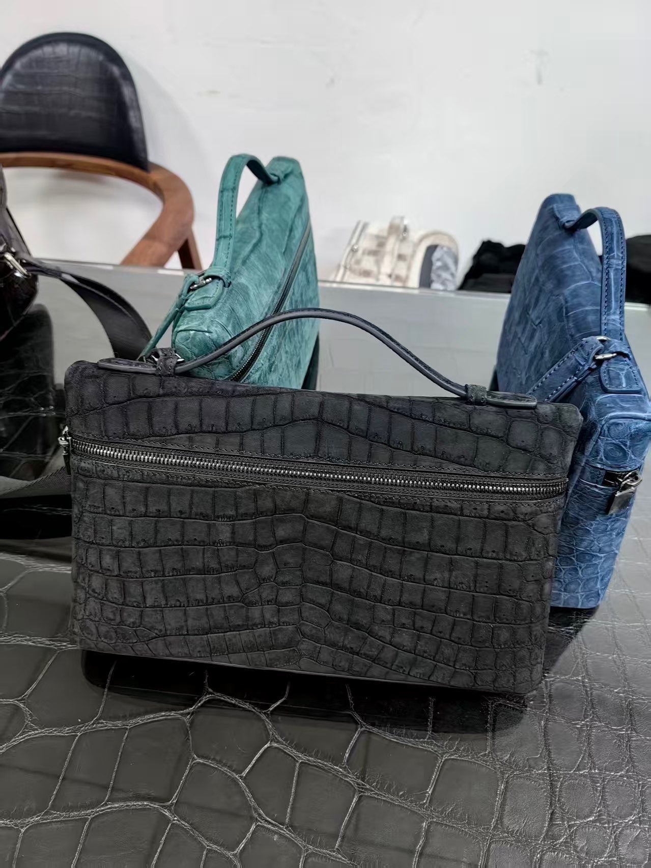 Black Rossie Viren unisex crocodile skin leather clutch bag with zipper handle and compact design.