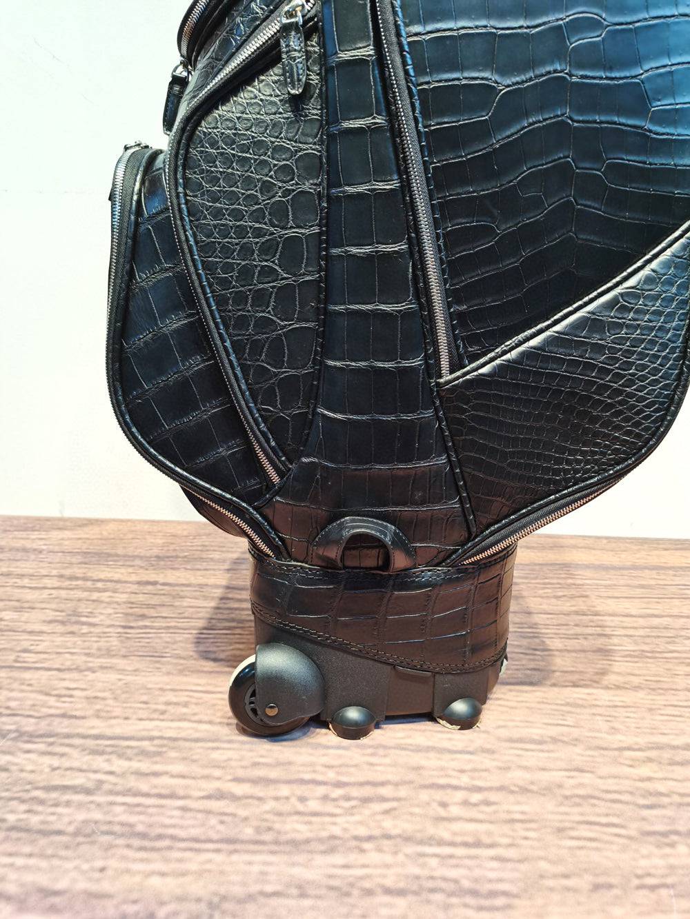 Rossie Viren crocodile belly leather golf set with black golf cart and stand bags, featuring roller wheels for easy transport.