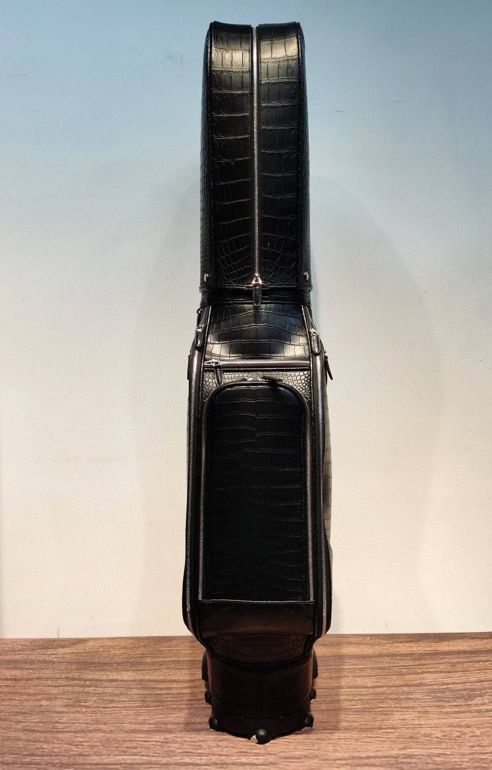 Black Crocodile Belly Leather Golf Bag from Rossie Viren, featuring multiple compartments and a roller for easy transportation.