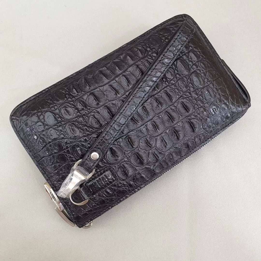 Black crocodile bone leather clutch bag with a band string by Rossie Viren, showcasing textured crocodile pattern and sleek design.