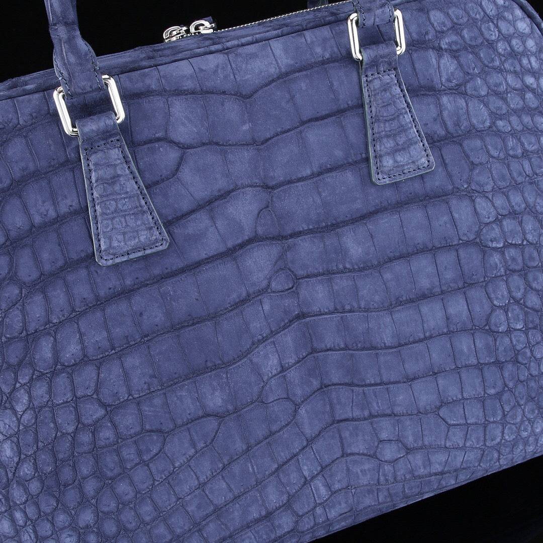 Blue genuine crocodile leather briefcase with structured design and top handle, designed for laptops and professional use.