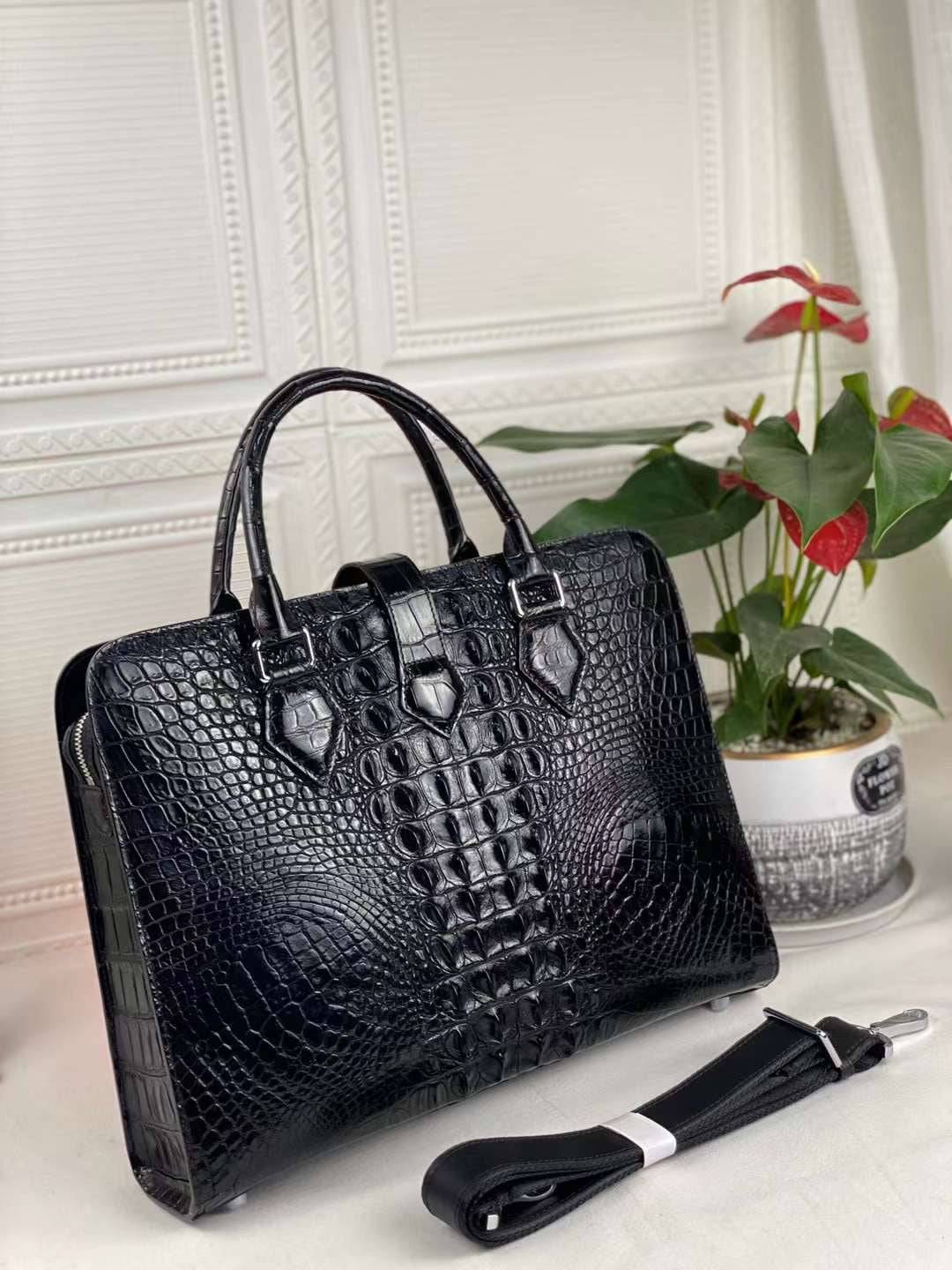 Black genuine crocodile leather briefcase with sturdy handles and sleek design, perfect for carrying laptops and documents.