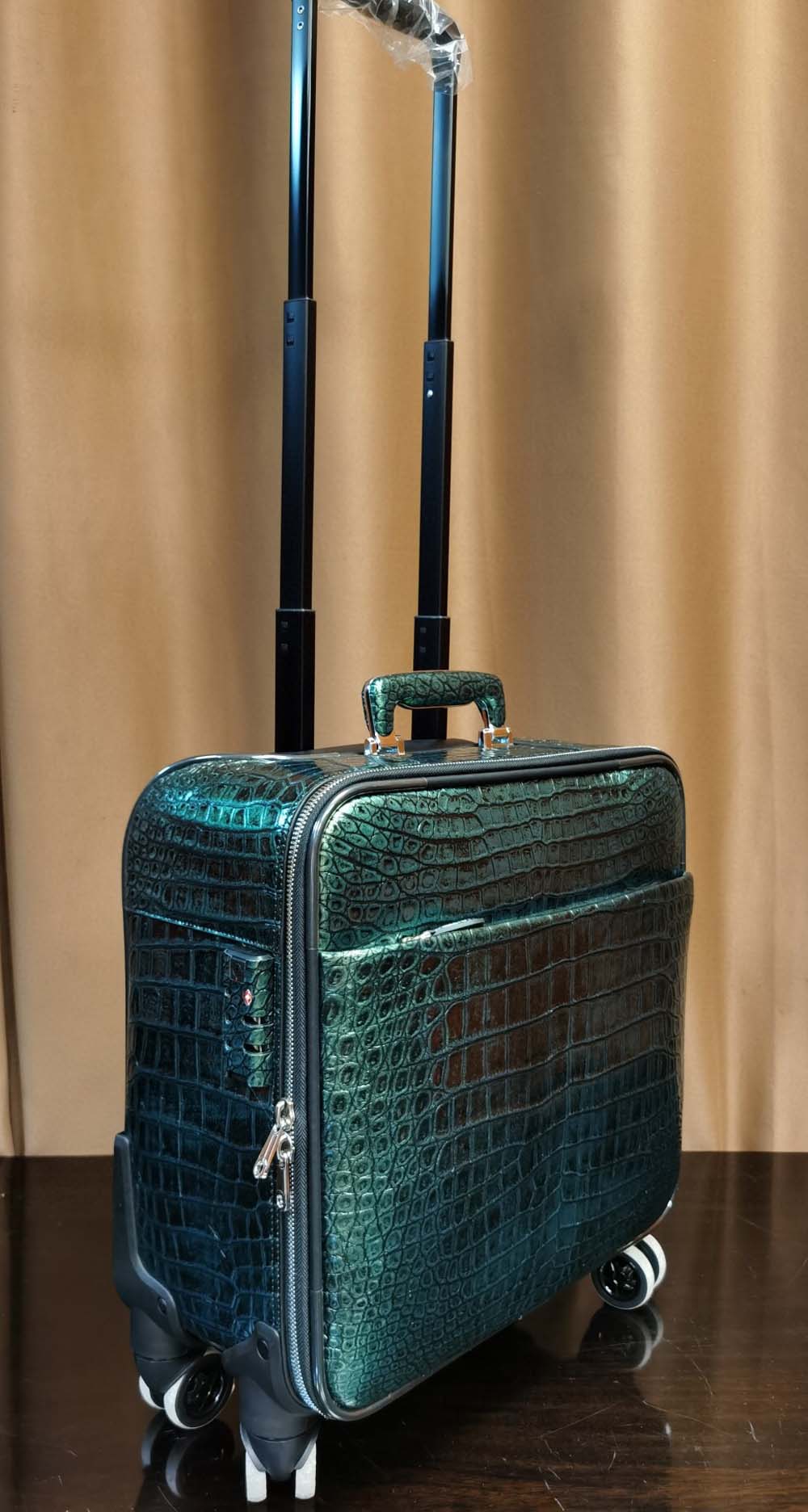Dark green crocodile leather 15-inch mini carry-on suitcase by Rossie Viren with sturdy handles and sleek design.