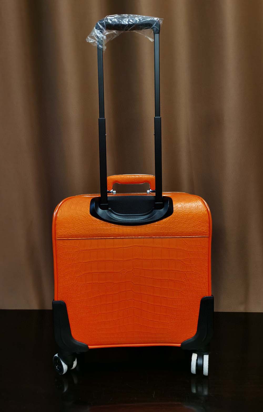 Orange crocodile leather 15-inch mini carry-on suitcase by Rossie Viren, featuring a textured crocodile pattern and compact design.