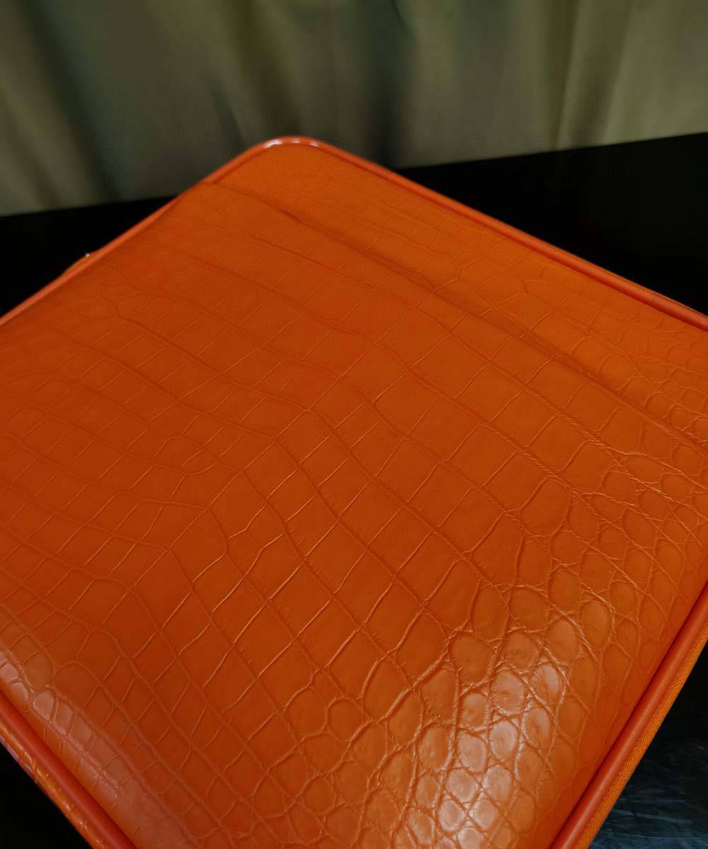 Orange crocodile leather 15-inch mini carry-on suitcase by Rossie Viren, featuring a textured surface and compact design for travel.