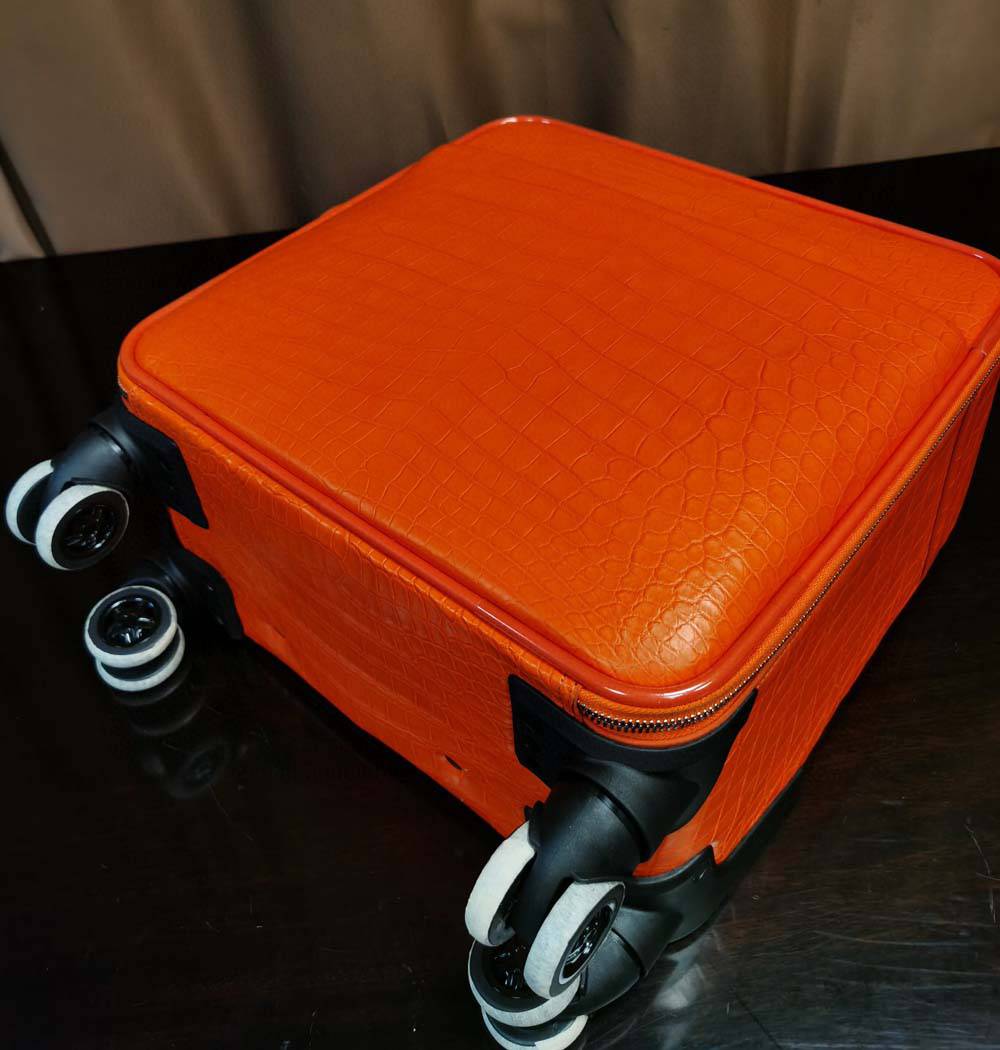 Orange crocodile leather 15-inch mini carry-on suitcase by Rossie Viren, featuring a compact and stylish design with textured leather.