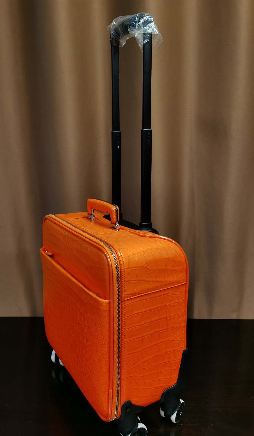 Orange crocodile leather 15-inch mini carry-on suitcase by Rossie Viren, featuring textured crocodile pattern and durable handle.
