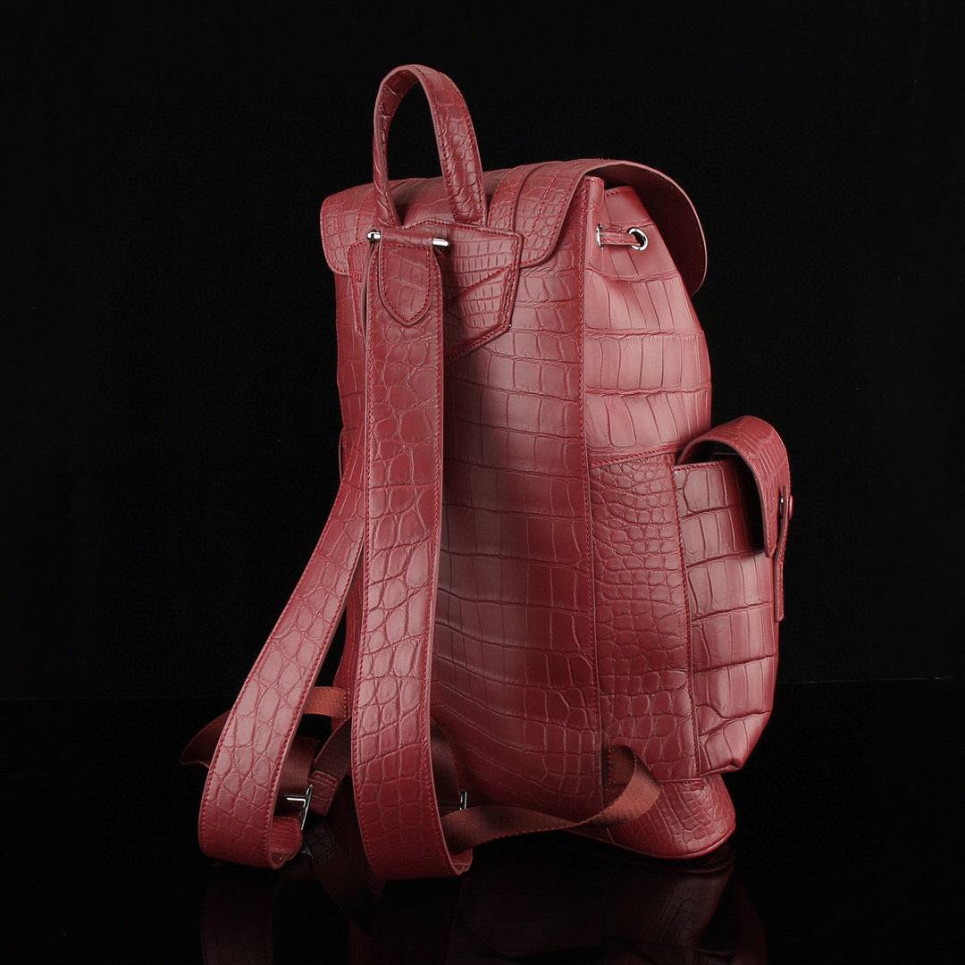 Rossie Viren crocodile leather backpack in wine red with a textured crocodile pattern and sturdy leather straps.