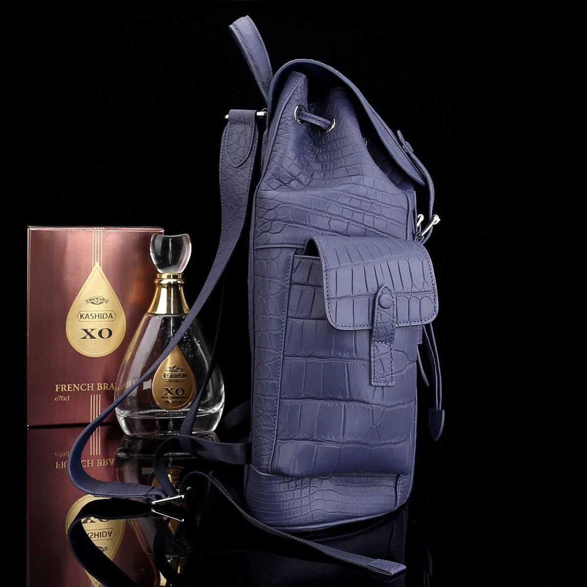 Dark blue crocodile leather backpack by Rossie Viren with sturdy straps and textured crocodile skin surface.