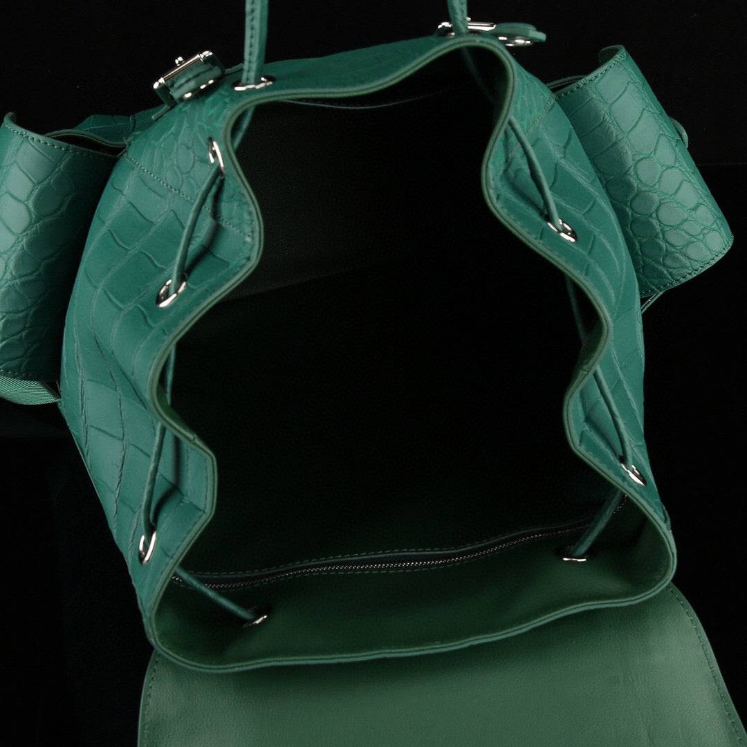Dark green crocodile leather backpack by Rossie Viren with sturdy straps and a sleek, textured surface.