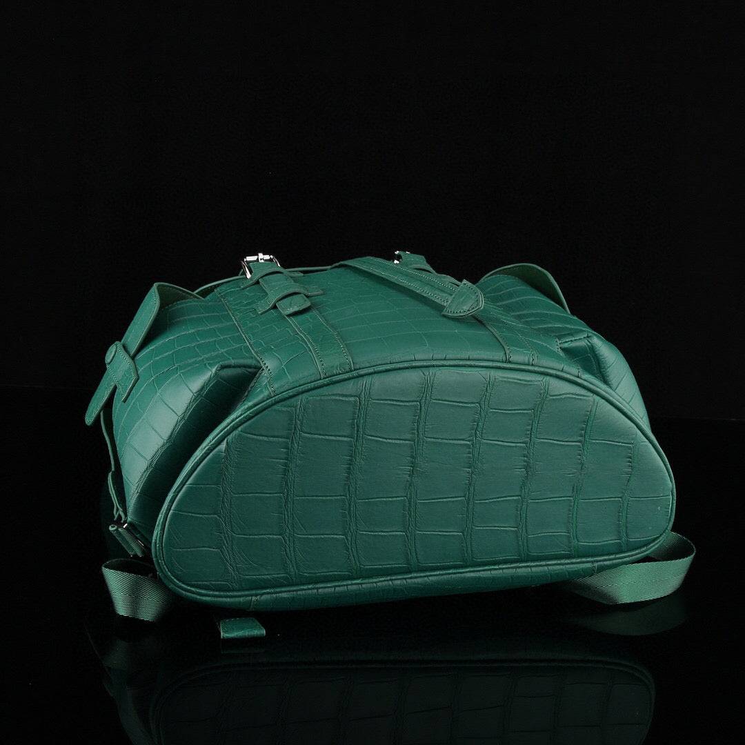 Dark green crocodile leather backpack by Rossie Viren, featuring a structured design with adjustable straps and minimalist style.