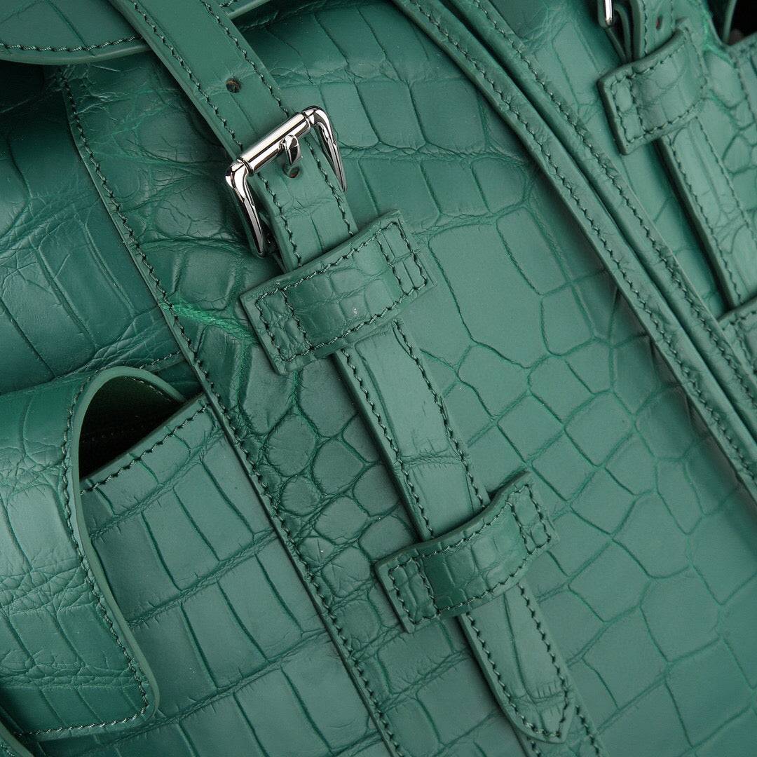 Dark green crocodile leather backpack by Rossie Viren, featuring textured crocodile pattern and adjustable shoulder straps.
