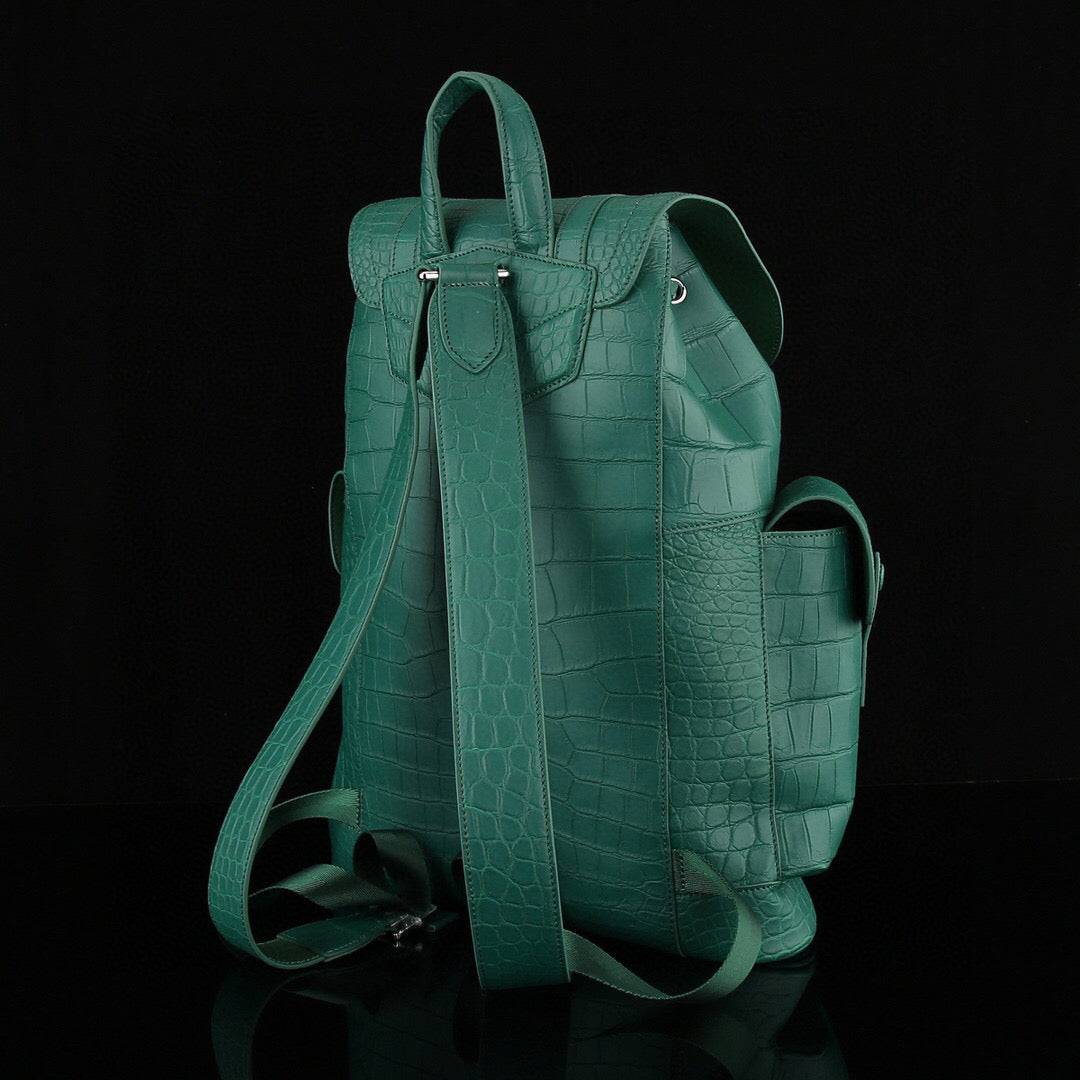 Dark green crocodile leather backpack by Rossie Viren showing textured crocodile pattern and sturdy shoulder straps.