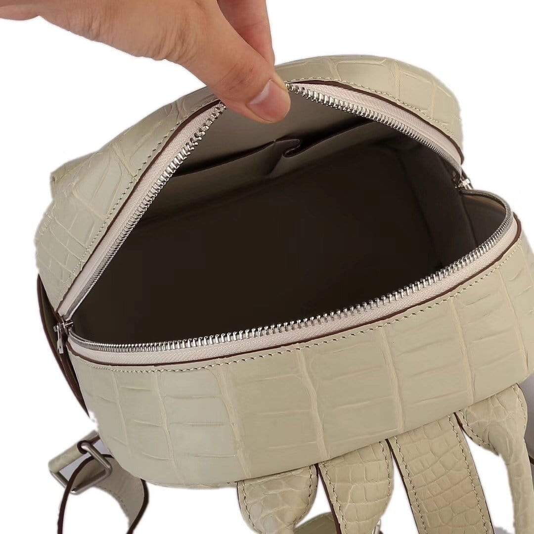 Cream crocodile leather handbag for women by Rossie Viren, stylish backpack with textured crocodile pattern and adjustable straps.