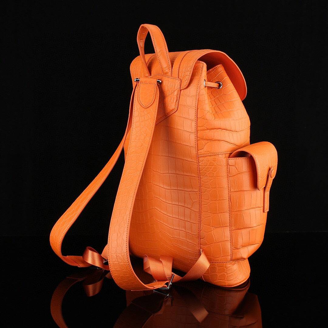 Orange crocodile leather backpack by Rossie Viren, featuring a textured crocodile pattern and adjustable straps.