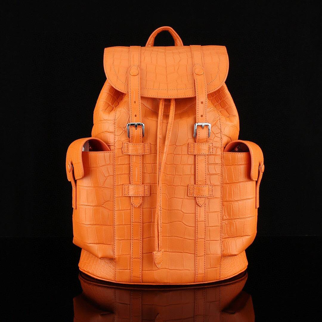 Orange crocodile leather backpack by Rossie Viren with a sleek design and textured crocodile pattern on the surface.