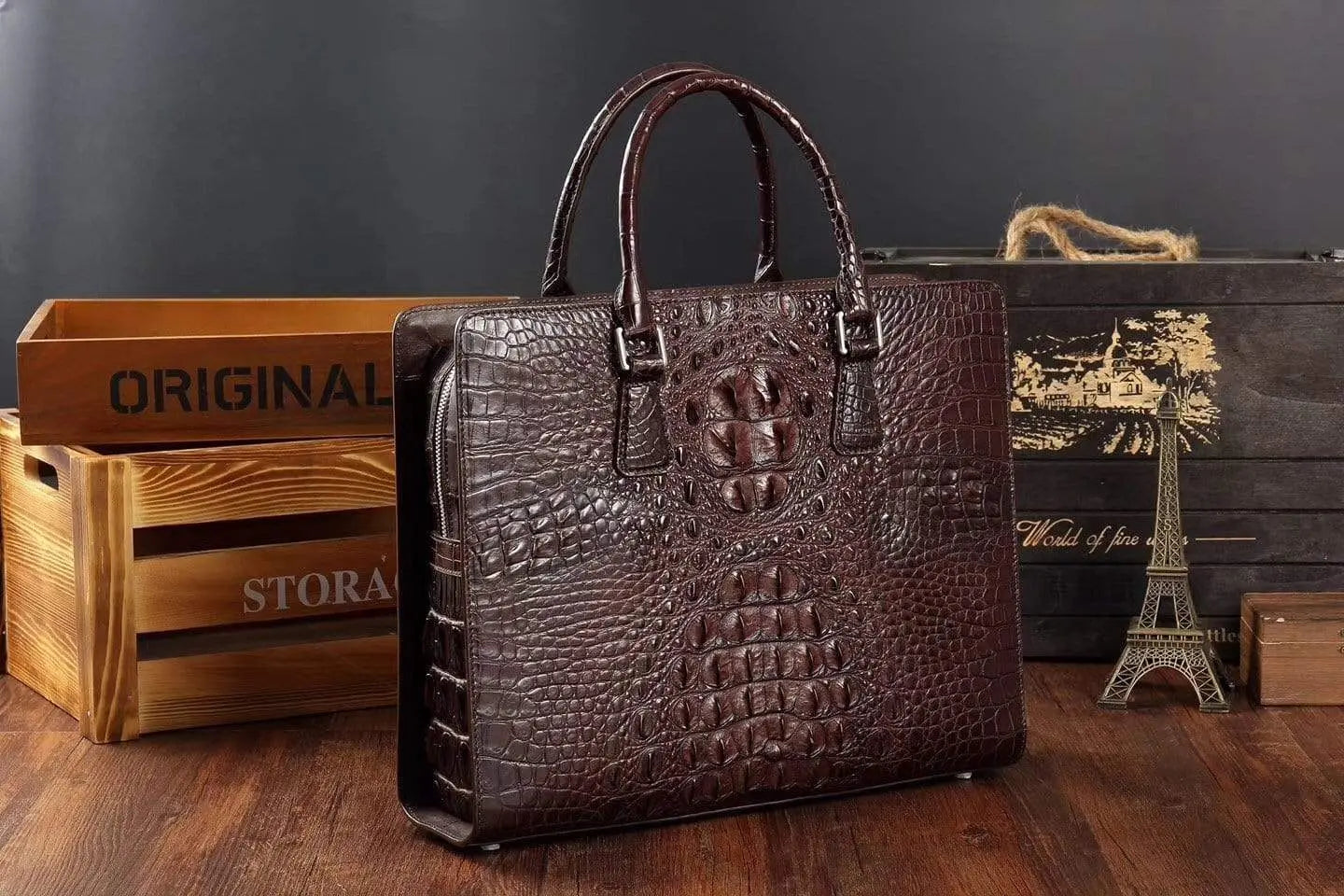 Rossie Viren crocodile leather briefcase handbag with polished metal hardware and sturdy handle on a plain background.
