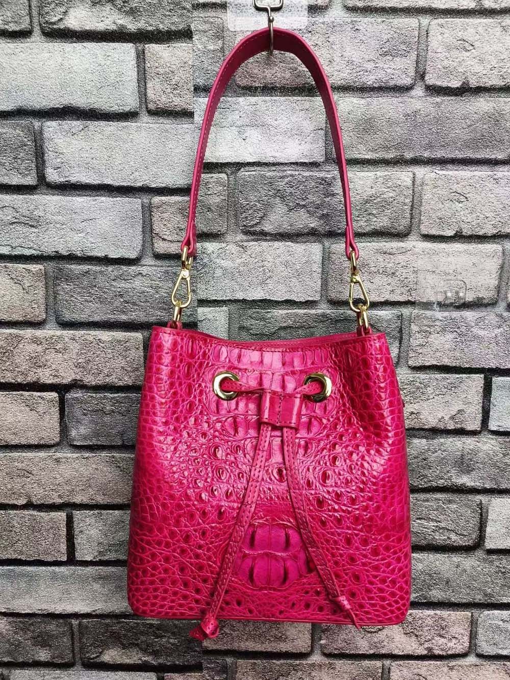 Rossie Viren crocodile leather bucket handbag with gold accents and adjustable strap, showcasing luxurious textured exterior.
