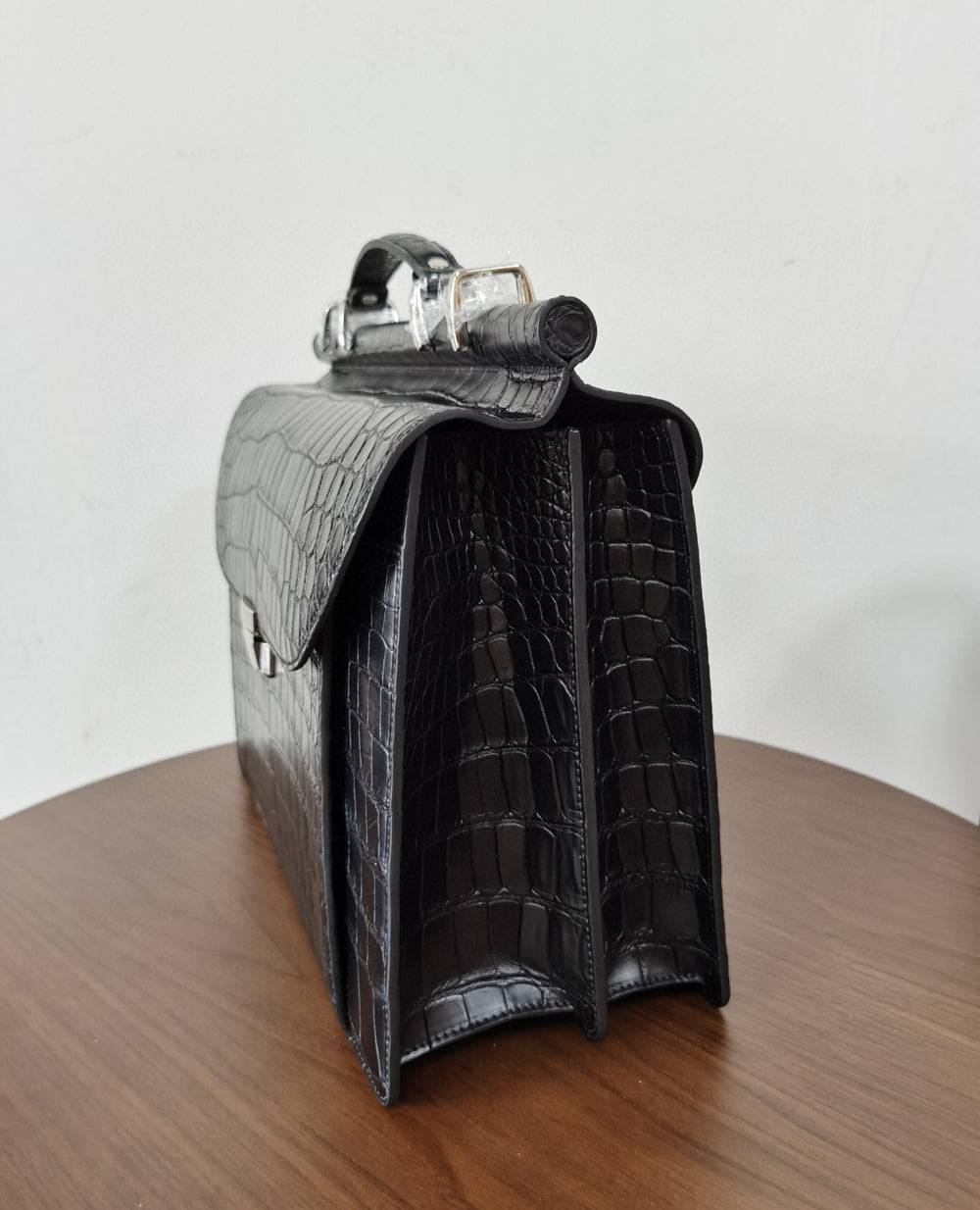 Black crocodile leather business briefcase by Rossie Viren, featuring a sleek, professional handbag with a textured crocodile pattern.