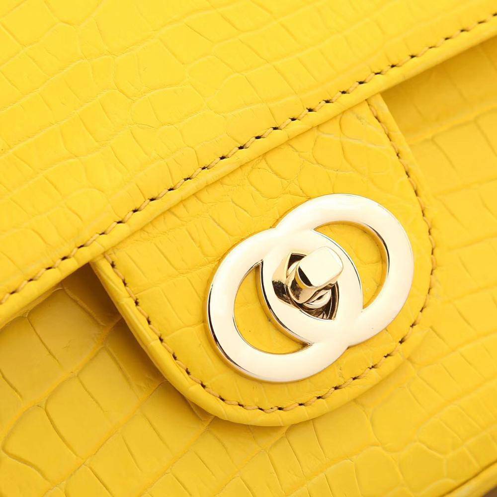 Yellow crocodile leather handbag with a classic flap and chain shoulder strap, designed for women by Rossie Viren.