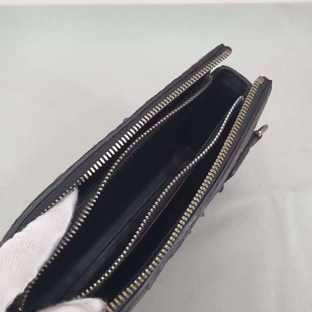 Rossie Viren crocodile bone leather clutch bag showing textured crocodile pattern and sleek design with a flap closure.