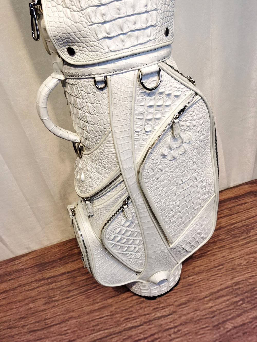 White crocodile leather golf bag set by Rossie Viren, includes cart and stand golf bags with textured crocodile pattern.