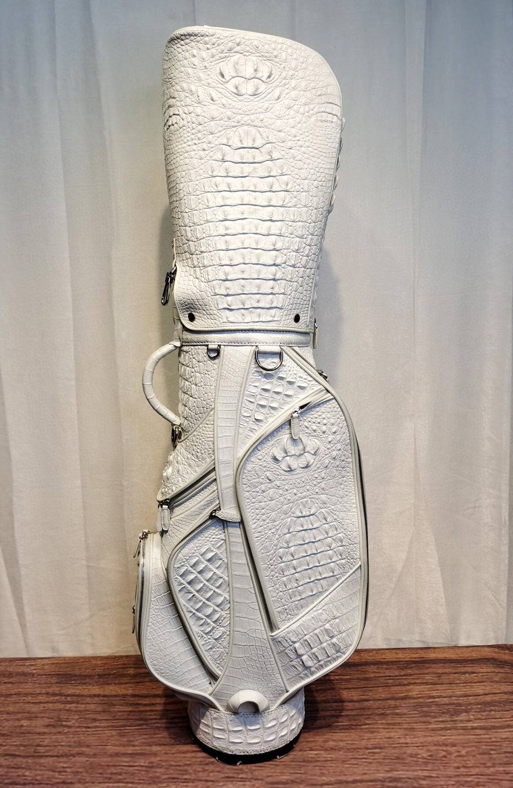 White crocodile leather golf bag from Rossie Viren, part of a golf set, with cart and stand bag features.