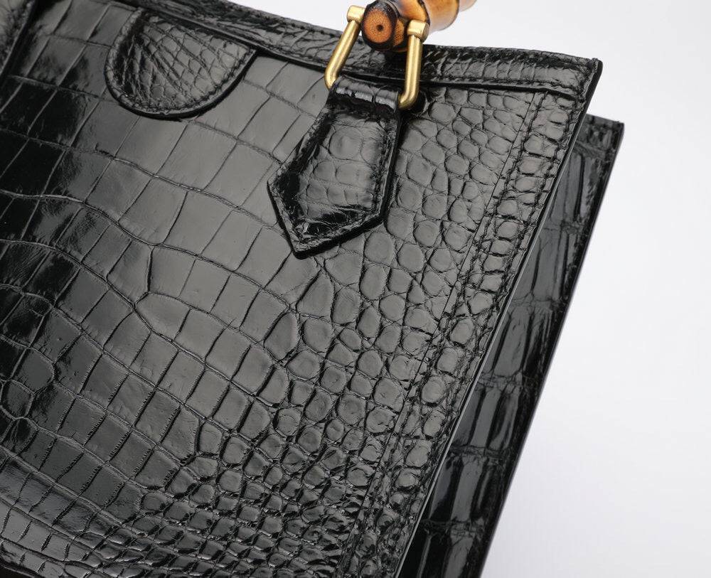 Rossie Viren crocodile leather micro top handle crossbody handbag with a sleek, structured design and adjustable strap.